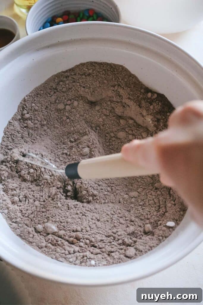 whisking brownie mixes and dry ingredients in a large mixing bowl.