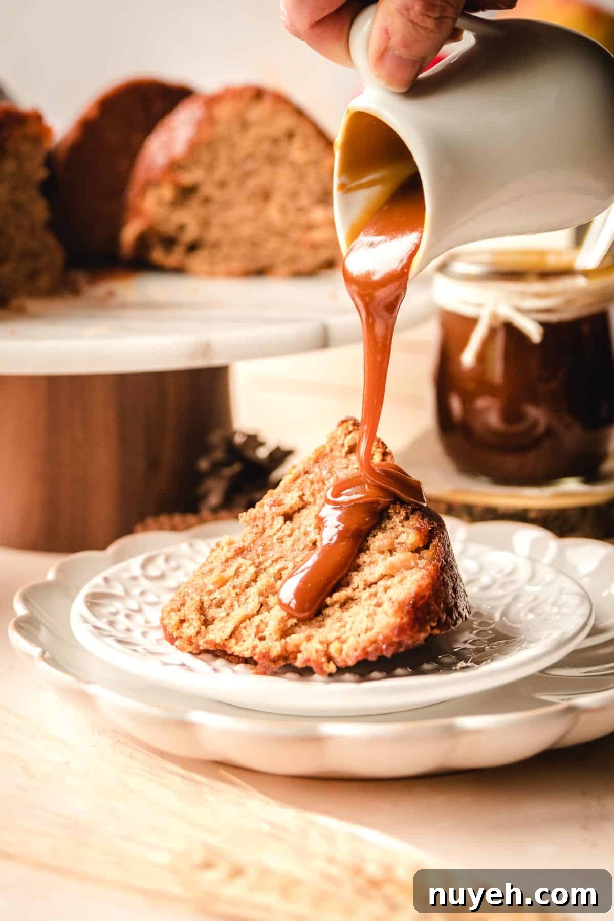 Spiced Apple Cider Bundt Cake with Cinnamon Glaze 4 Pouring salted caramel sauce over a slice of spiced apple cider cake.