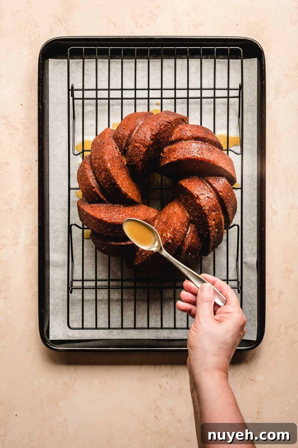 Spiced Apple Cider Bundt Cake with Cinnamon Glaze 5 Pouring apple cider reduction over top an apple cider cake.
