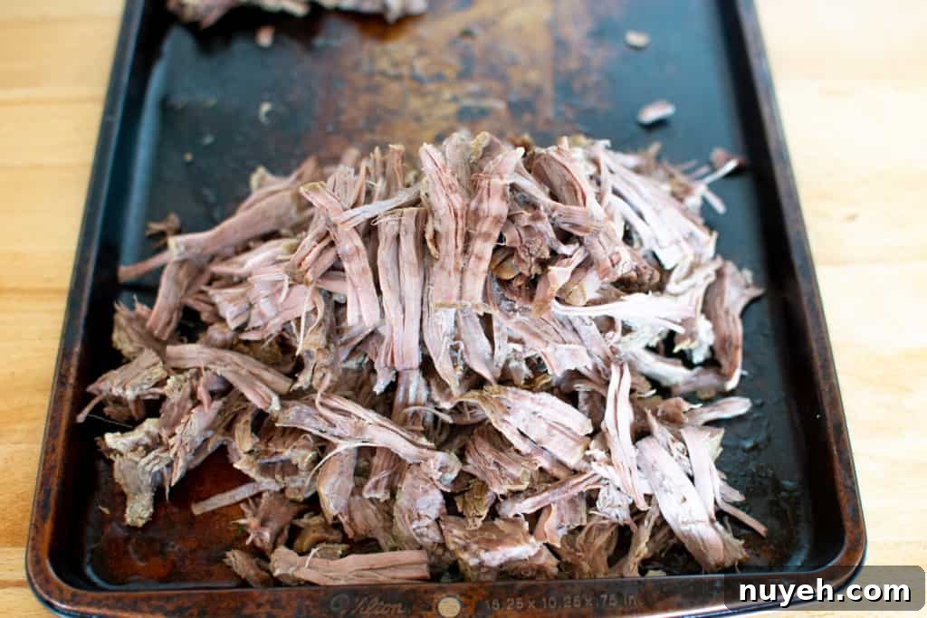 Shredded beef on a baking sheet.