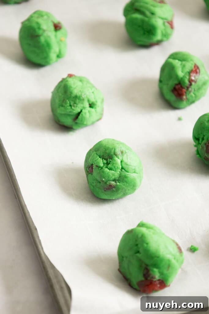 Dough balls on a parchment lined baking sheet.