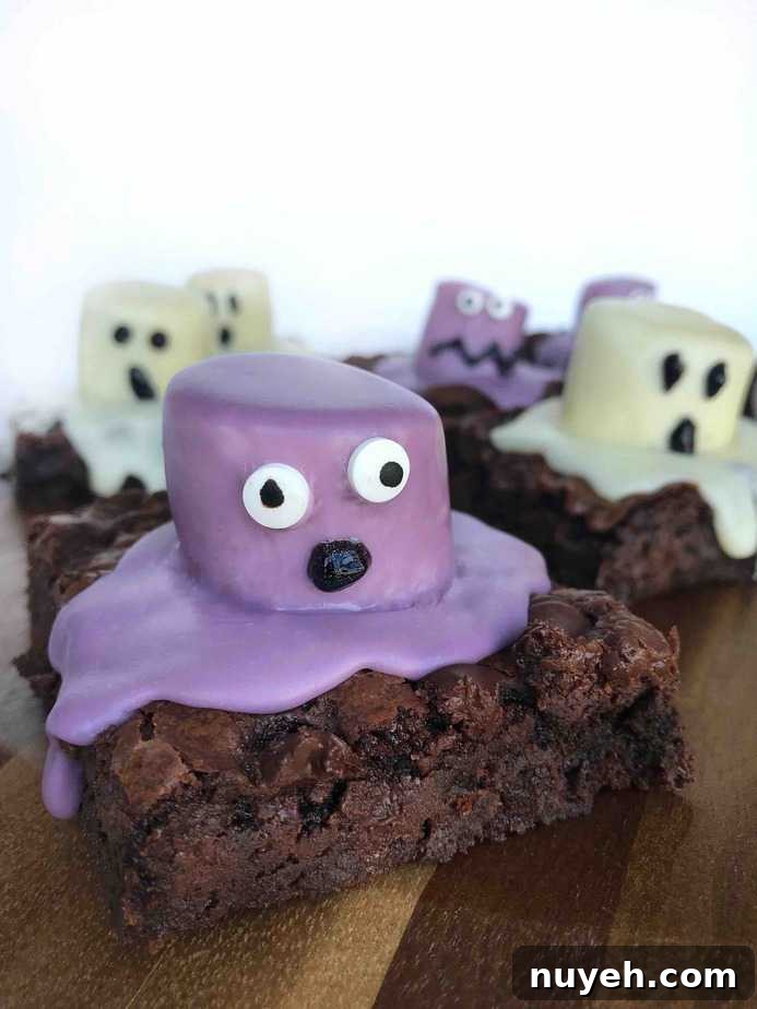 purple monster brownie with OH shaped mouth on wooden board with ghost brownies in background