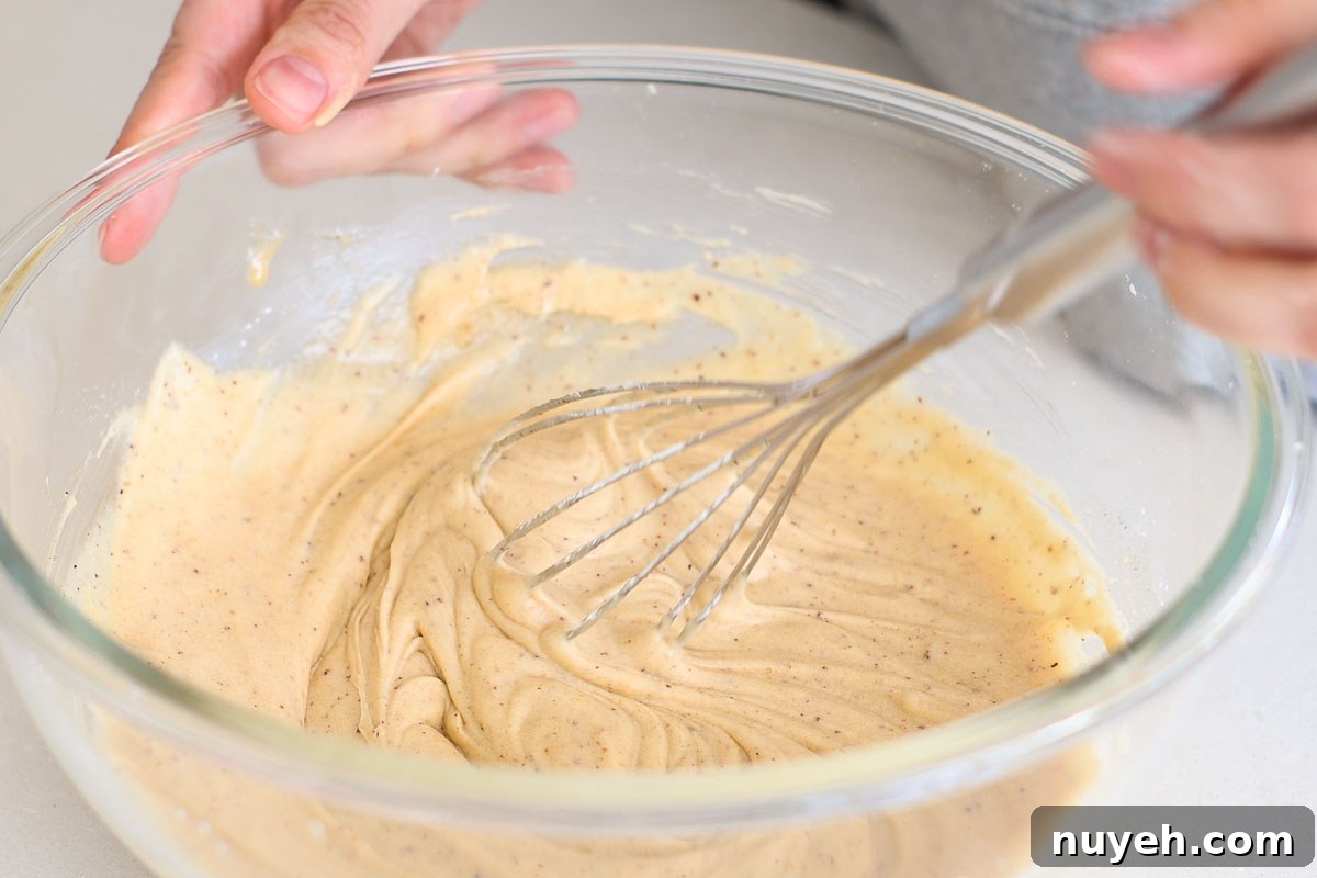 Dough whisked in a glass bowl.