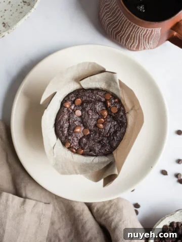 Chocolate muffin on a white plate.