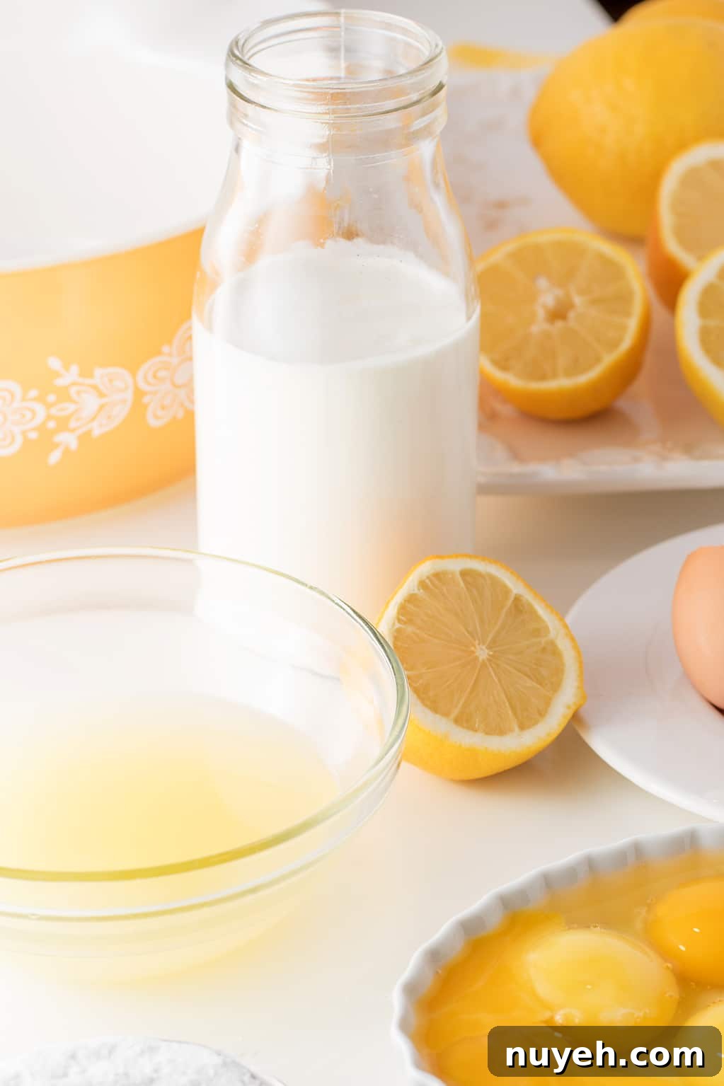 lemons, cream, egg whites and egg yolks on a white background