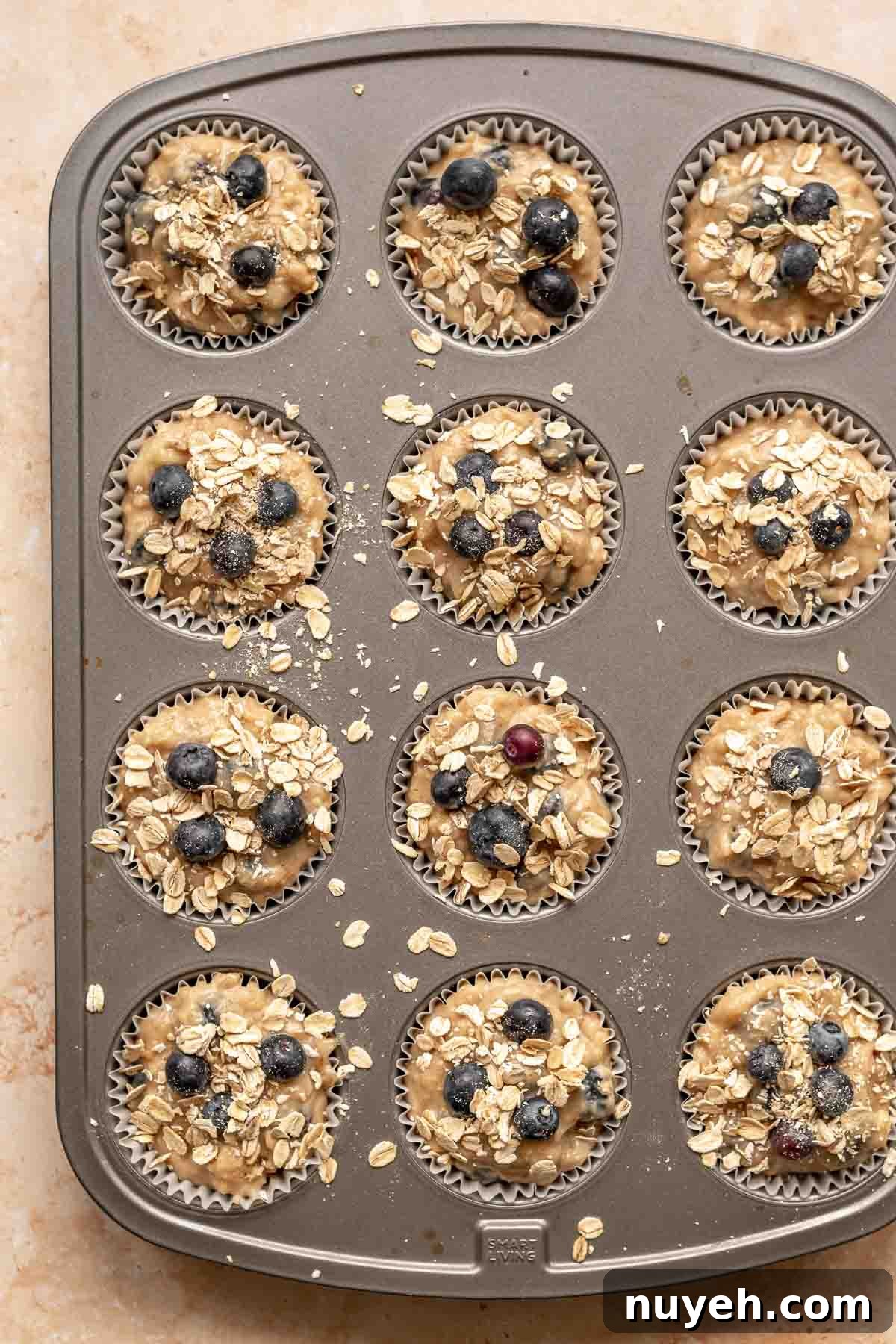 Pre-baked muffins with oats scattered on top.