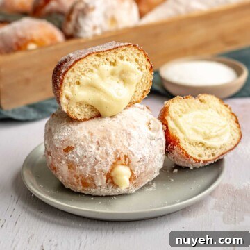 Custard donuts stacked on a plate.