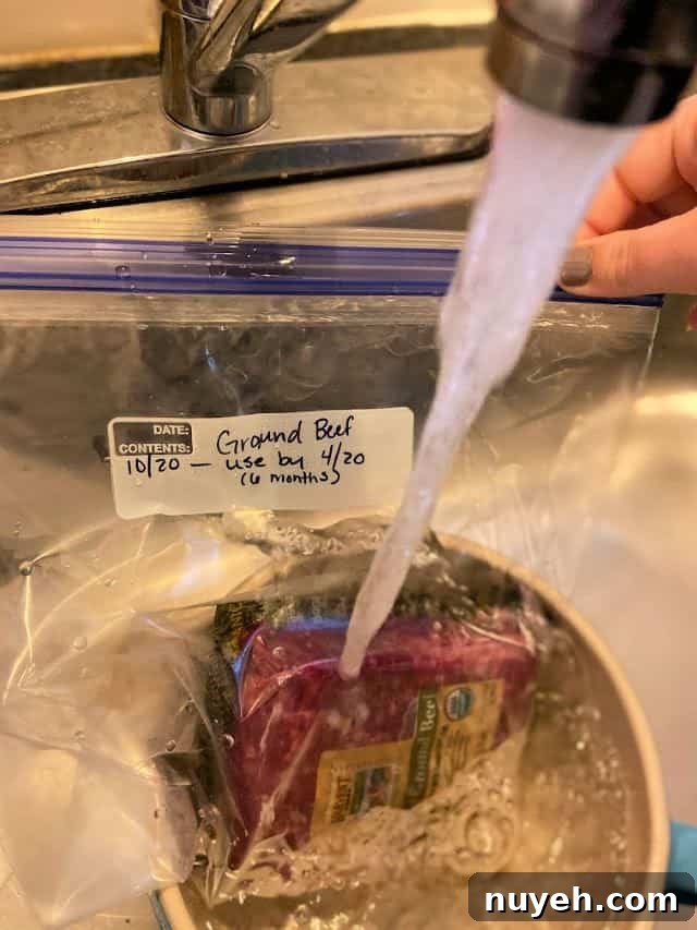 How to Thaw Ground Beef Safely: Refrigerator, Cold Water, Microwave 3 Water running over a package of ground beef