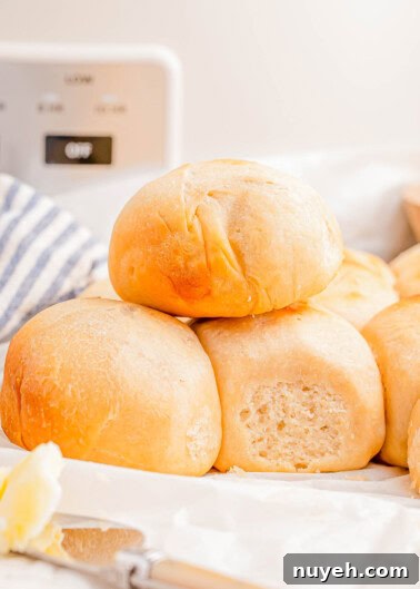 A stack of freshly baked dinner rolls on a table.