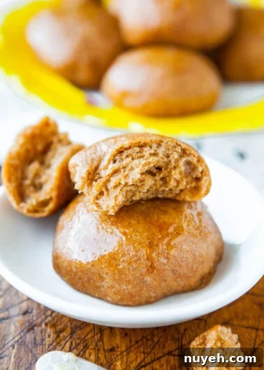 Glazed gingerbread spice donuts with one split open to show the inside.