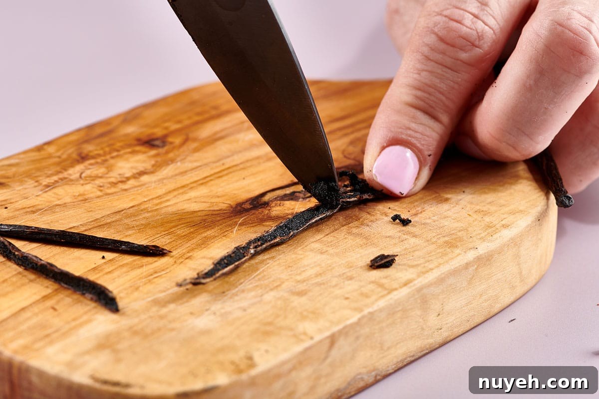 Scraping vanilla bean seeds out of the pod with a knife.