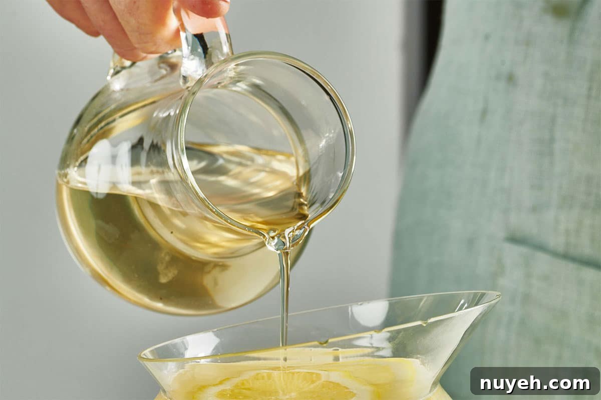 Simple Syrup pouring from a glass pitcher.