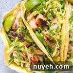 Salmon tacos on a plate with garnishes