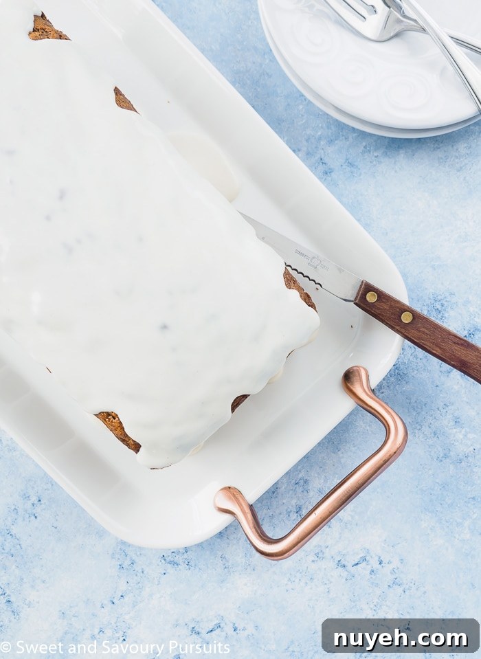 Moist Carrot Bread Recipe 4 Top view of an iced carrot cake loaf served on a white platter.