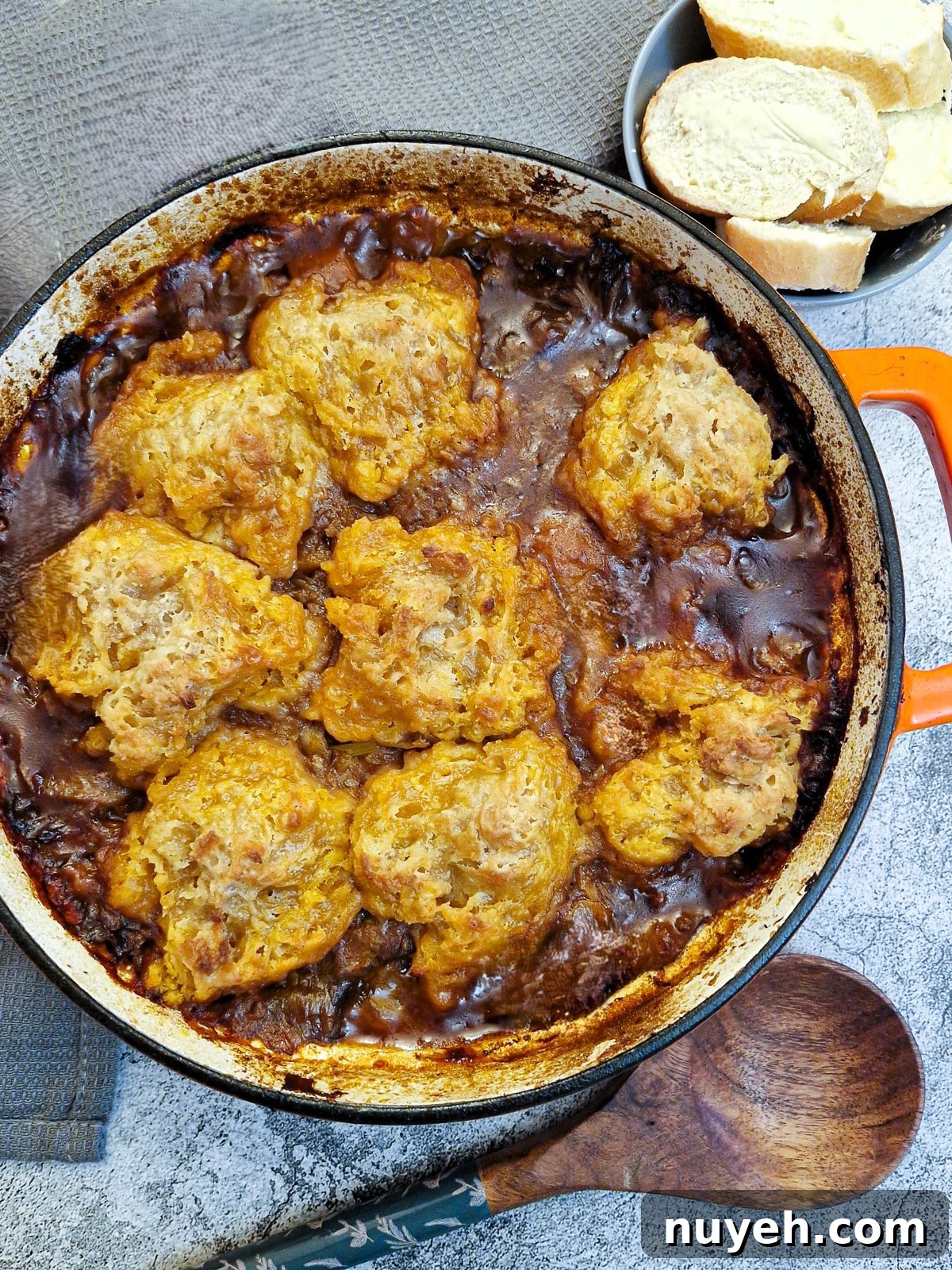 Overhead shot of a dish of beef casserole covered in suet dumplings.