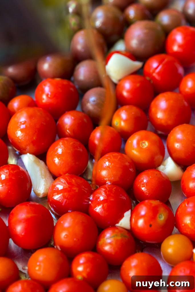adding olive oil to cherry tomatoes for confit