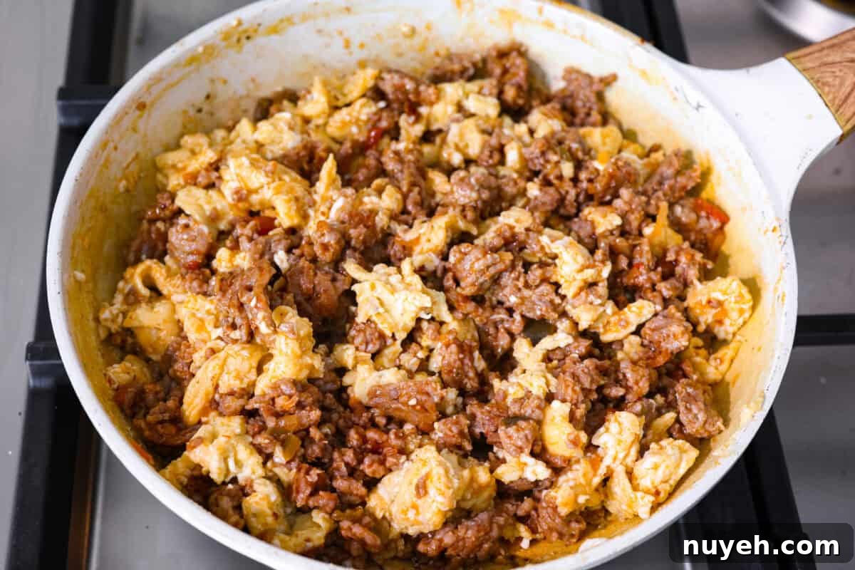 Scrambled eggs added to the cooked sausage and salsa