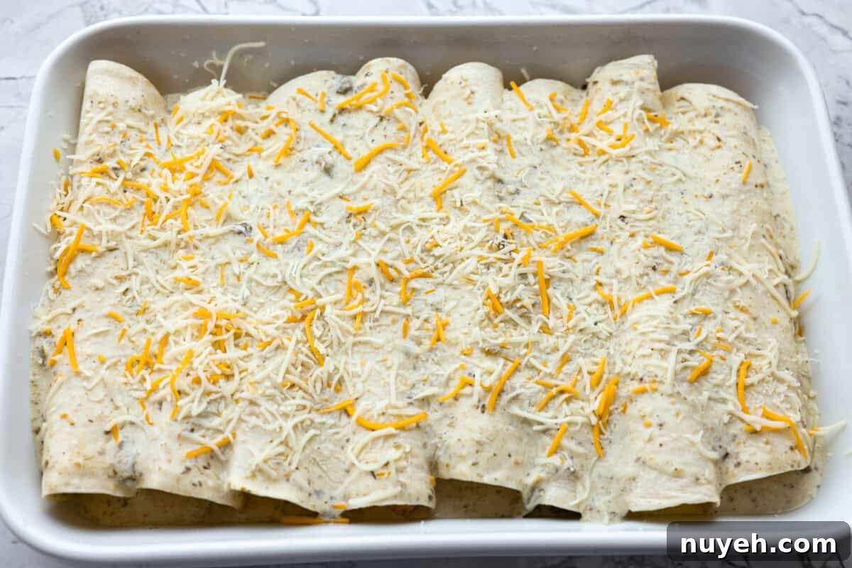 Breakfast enchiladas with sauce and cheese before baking