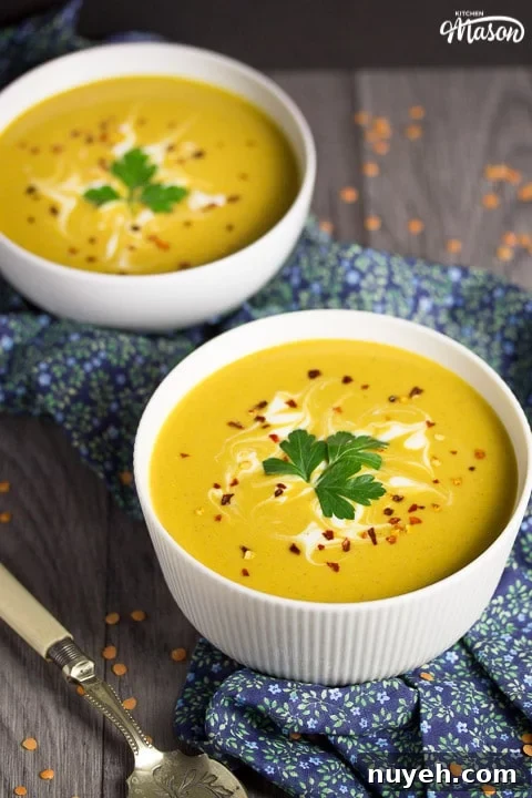 curried coconut lentil soup in a bowl with parsley and chilli flakes on top