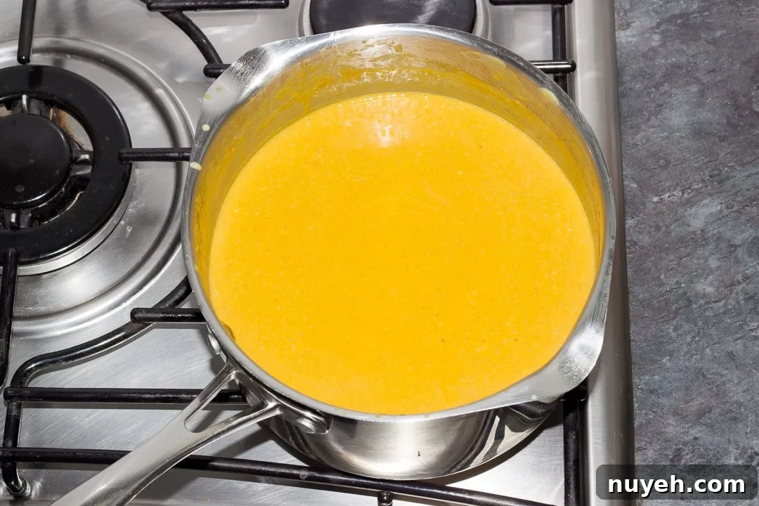 pureed curried coconut lentil soup simmering in a large pot on the hob