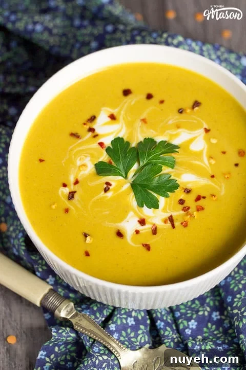 curried coconut lentil soup in a bowl with parsley and chilli flakes on top