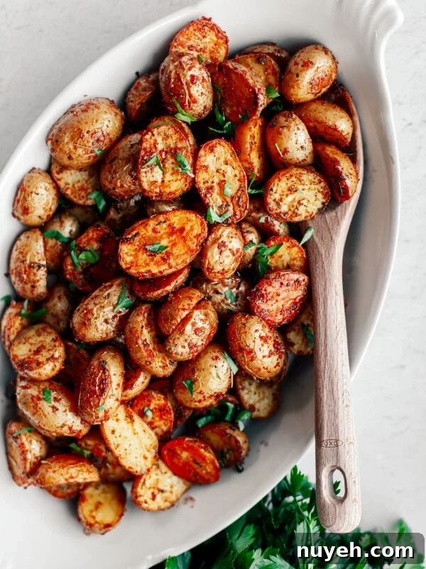 Serving platter of crispy potatoes garnished with parsley.