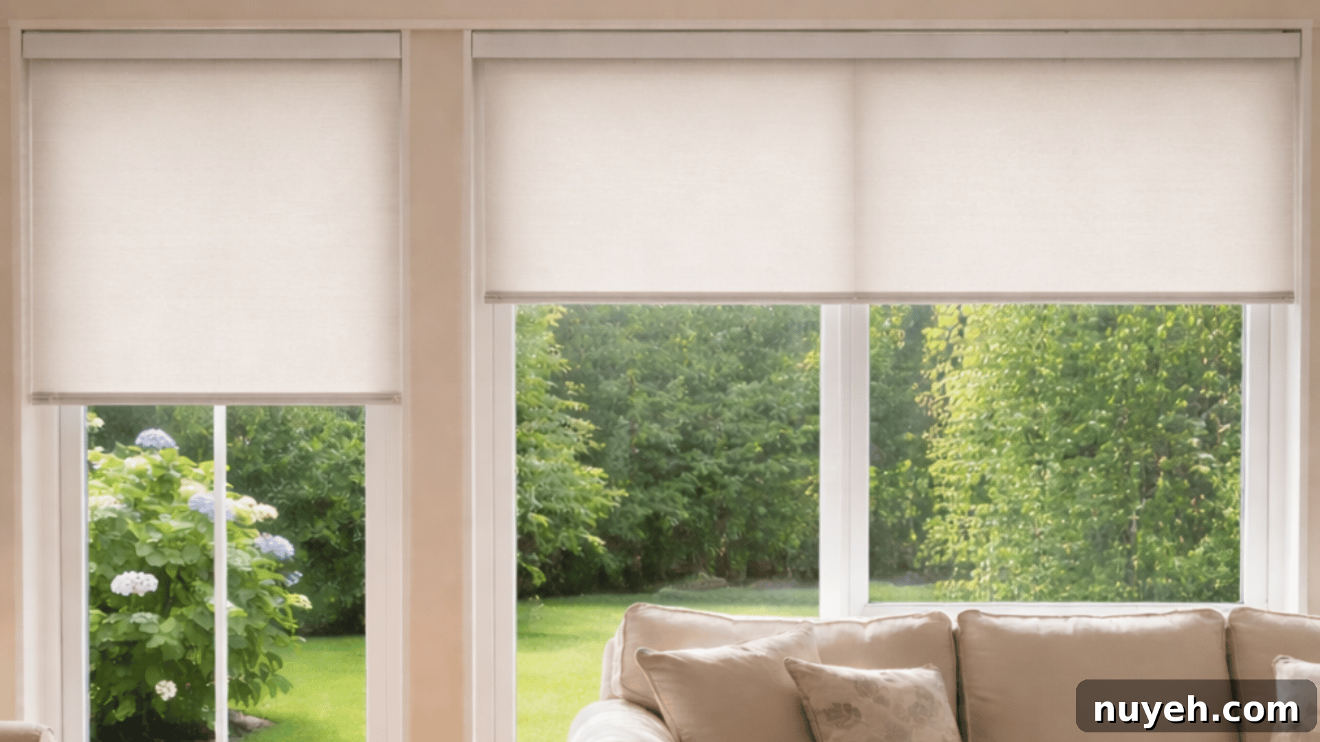 Shutters vs Blinds: Which Window Treatment Fits Your Home? 6 a bright living room with off-white roller blinds, a beige sofa, overlooking a lush garden.