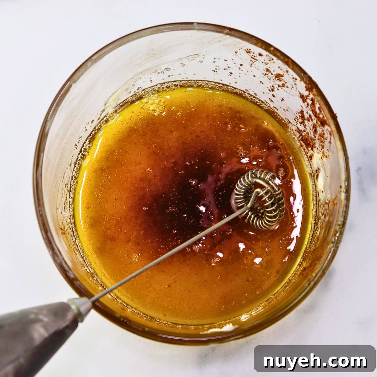 cooled brown butter bites in a glass container with a milk frother for whipping the butter for a whipped variation