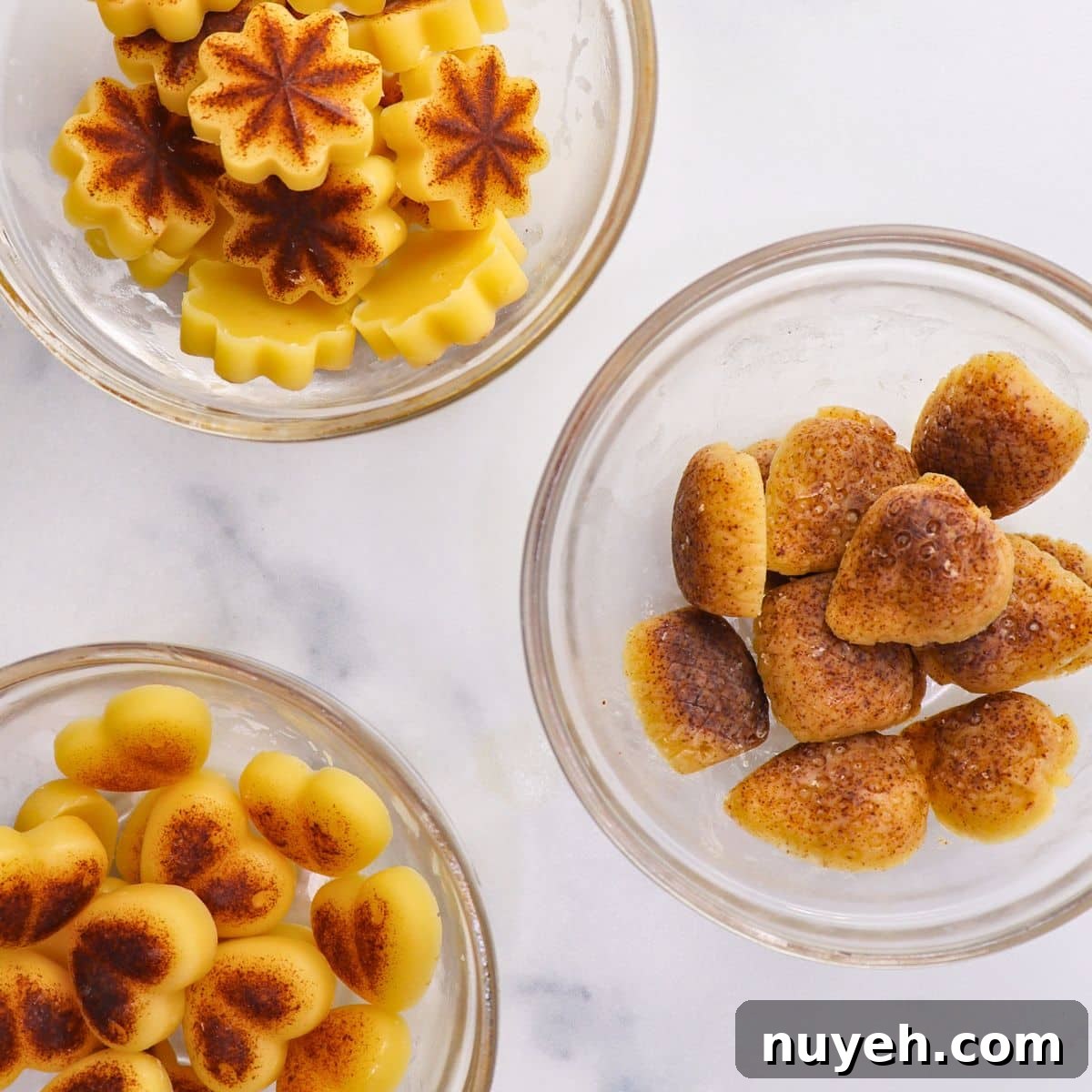 different shapes of brown butter bites including a flower, heart, and strawberry shaped in 3 glass bowls separated