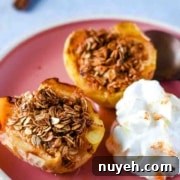 Air fryer baked apples are shown on a pink plate with whipped cream.