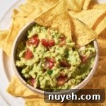 A bowl of 4-ingredient guacamole with tortilla chips.