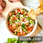 An overhead shot of garden fresh salsa in a white bowl.