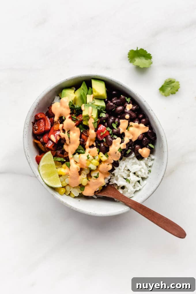 a burrito bowl with black beans, corn, avocado and peppers