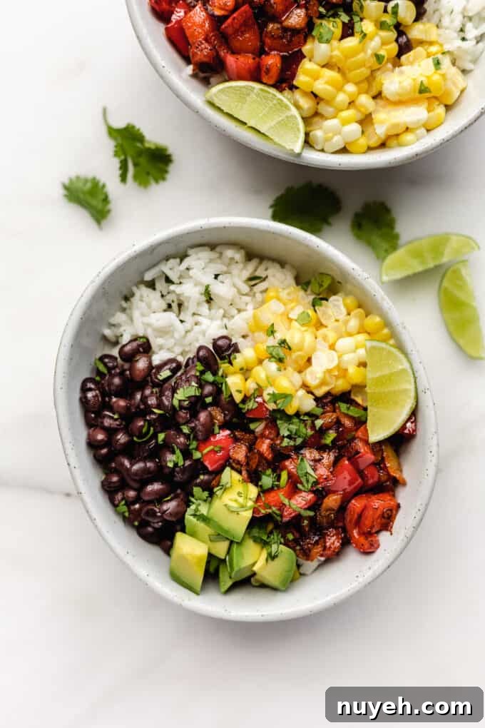 two vegan burrito bowls with vegetables, rice, black beans, peppers and avocado