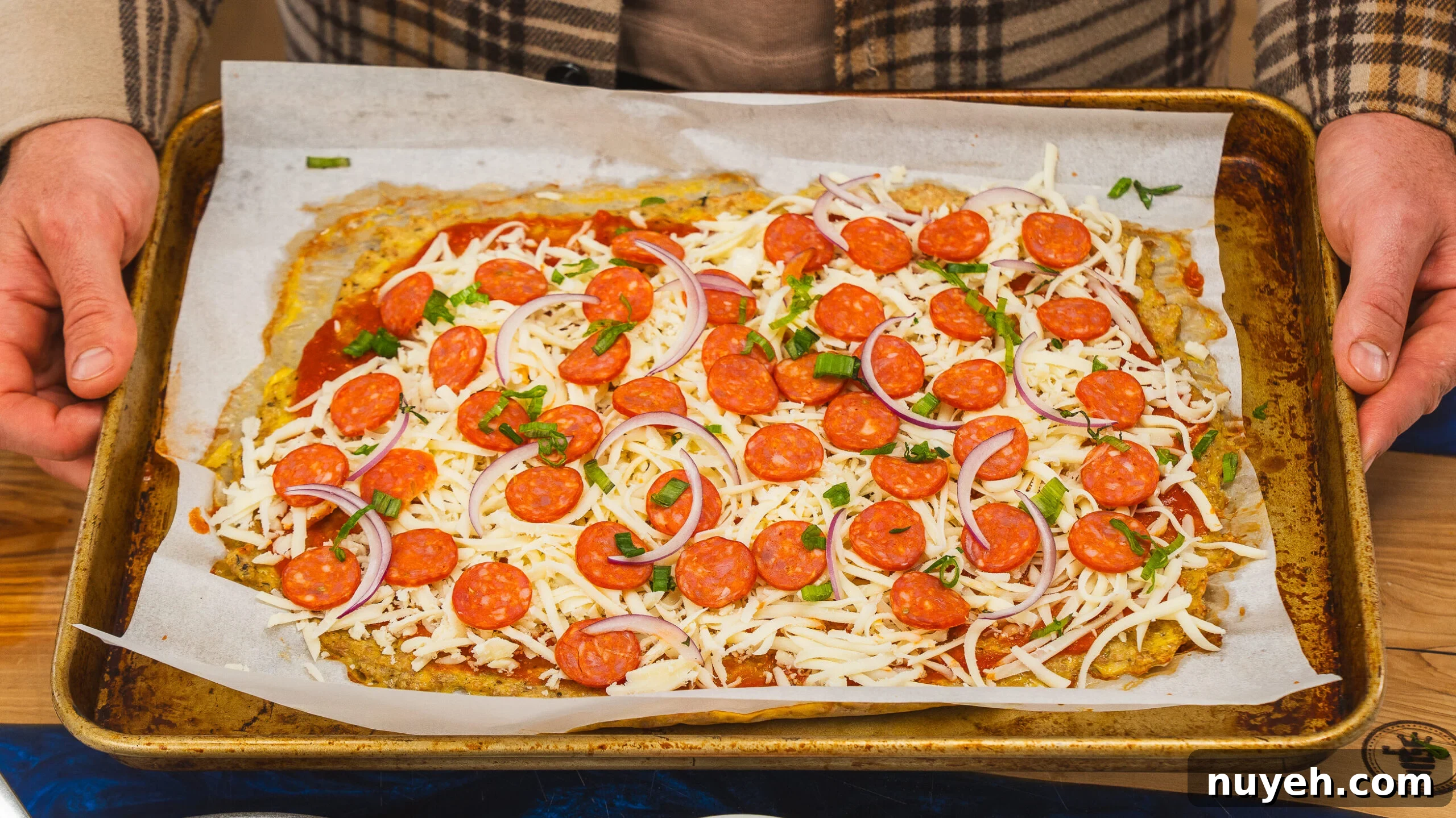 Chicken crust pizza on a baking sheet before baking