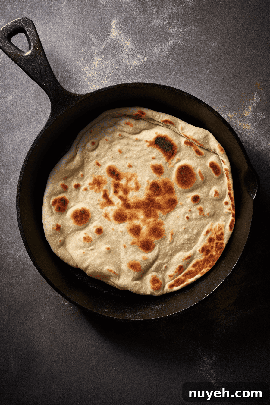Naan bread being cooked in a pan.