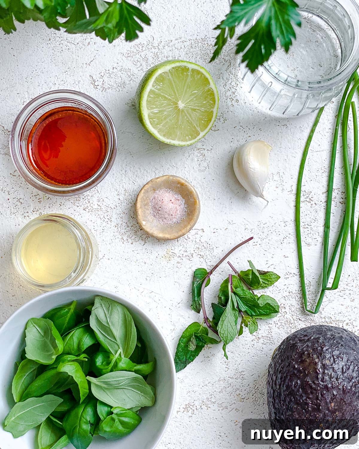 ingredients for Avocado Green Goddess Dressing measured out against a white surface