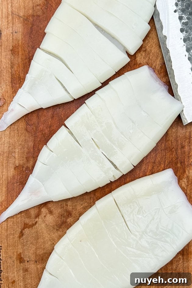 calamari tubes cleaned and scored on a cutting board