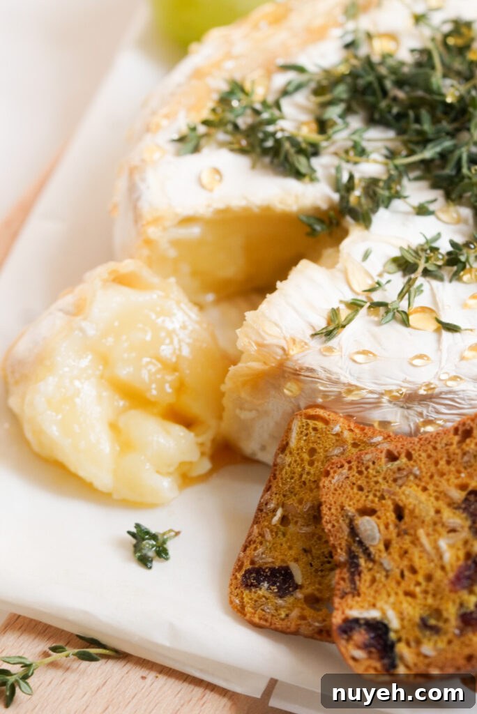 Air Fryer Baked Brie with Honey and Thyme 8 air fried brie with a piece cut out to show the interior; it is holding shape but is obviously somewhat melted.