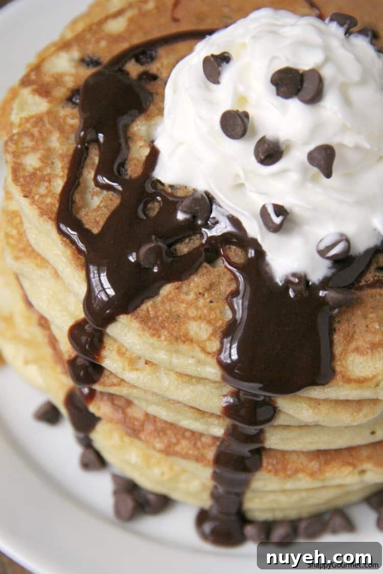 Almond Flour Chocolate Chip Pancakes - fluffy from scratch pancake recipe closeup of pancakes with whipped cream, chocolate chips, and chocolate syrup