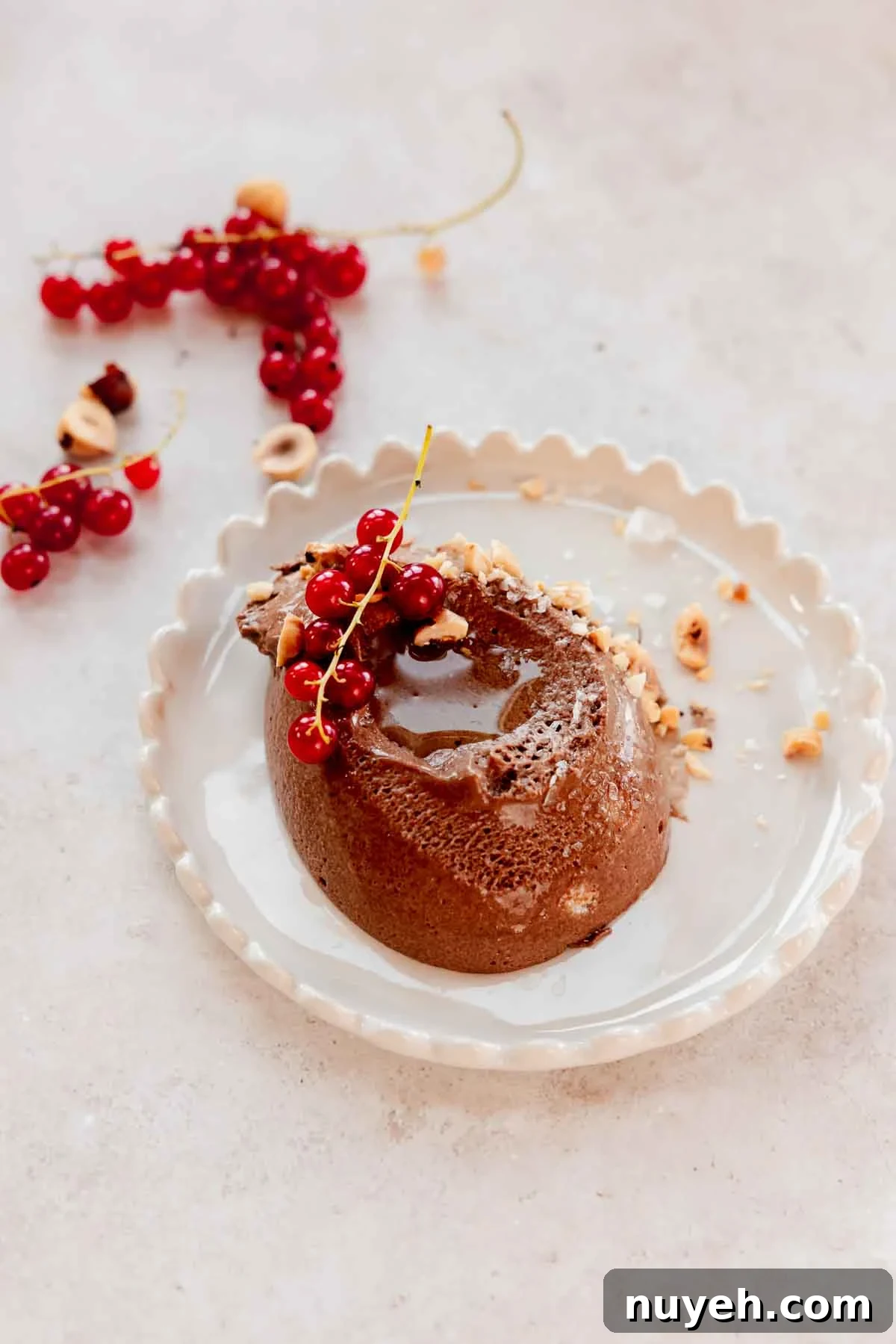 scoop of chocolate mousse on serving plate with berries and flaky salt and oil