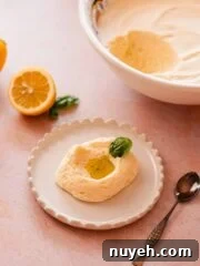 scoop of lemon mousse with lemon curd, olive oil, and basil leaf