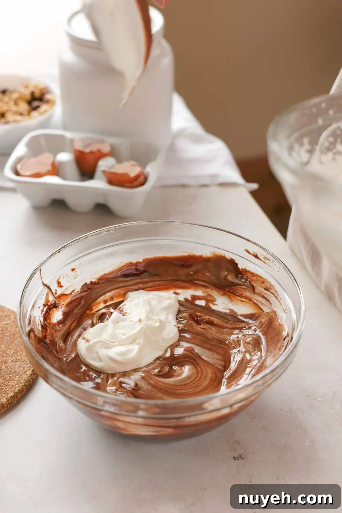 gradually folding whipped cream and egg whites into chocolate mixture