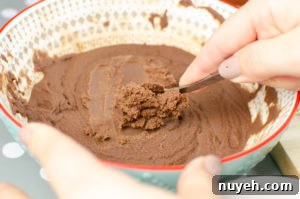 Scraping milk chocolate with a teaspoon to make our milk chocolate truffles