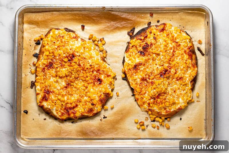 Large baking sheet with two Mexican street corn flatbreads freshly baked