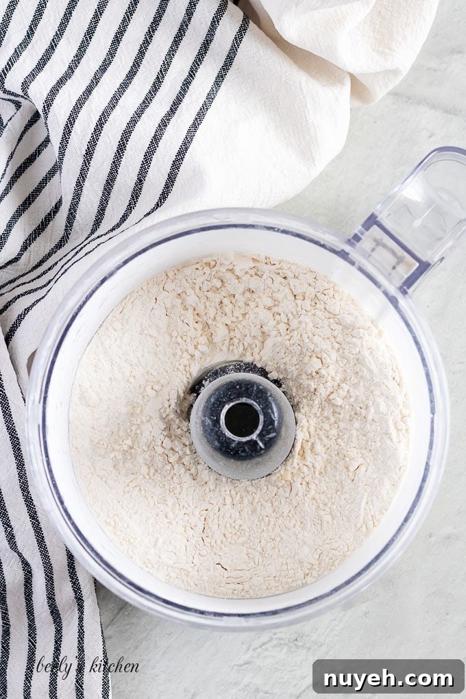 Top-down view of a food processor with the mixed dry ingredients.