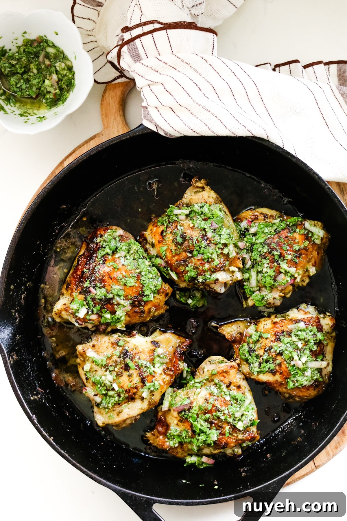 Grilled Chimichurri Chicken Thighs Recipe 2 chimichurri chicken thighs in cast iron skillet.