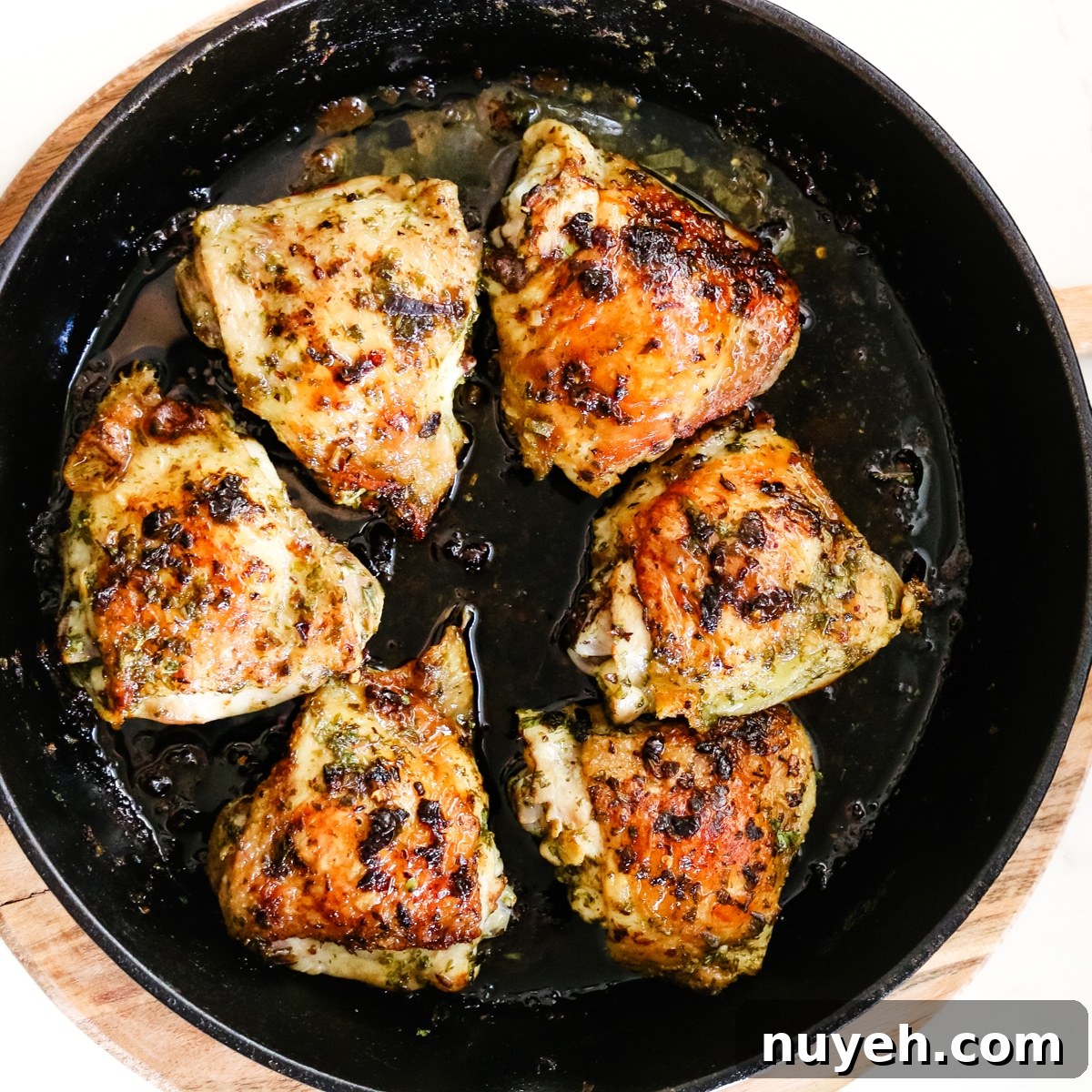 Grilled Chimichurri Chicken Thighs Recipe 9 cooked chicken thighs in cast iron skillet.