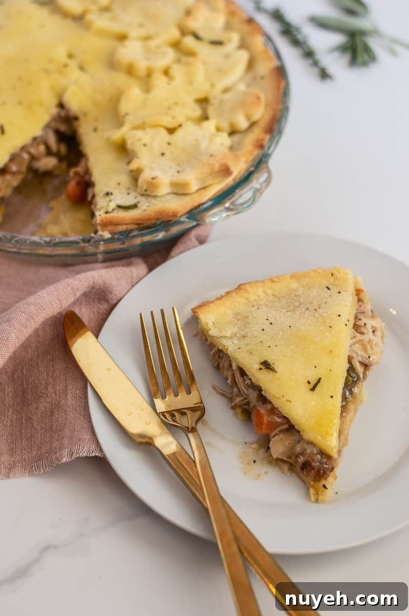 Slice of gluten-free chicken pot pie with gold flatware