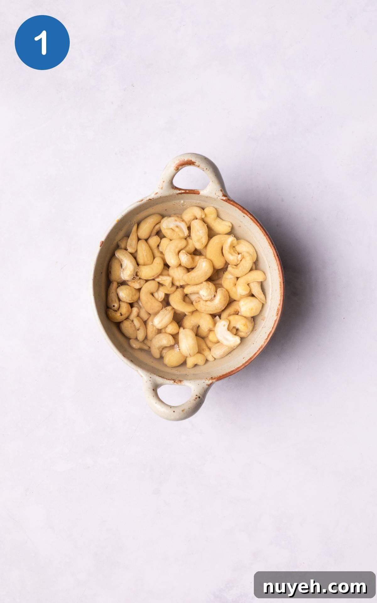 cashews soaking in a bowl with water.